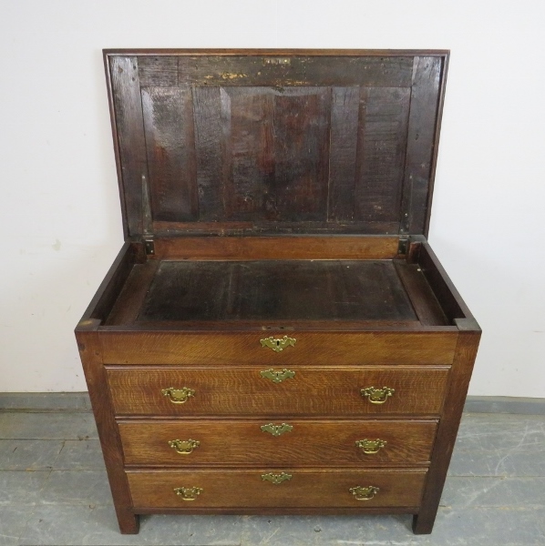 An antique oak chest in the 18th century taste, the panelled lid opening onto a shallow compartment, - Image 3 of 3