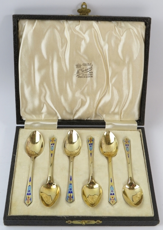 A boxed set of six silver gilt and enamel demitasse spoons with art nouveau decoration. Hallmarked