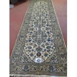 A central Persian Kashan runner, four central motifs on a cream ground. 300cm x 100cm (approx).