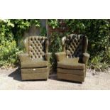 A pair of vintage Chesterfield style wingback armchairs, upholstered in faux green leather with