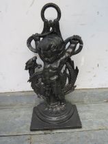 An antique style cast iron doorstop in the form of a cherub holding a dragon. H45cm W22cm D12cm (