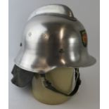 A 1980s Dutch Fire Service polished steel fire helmet with leather neck cowl.