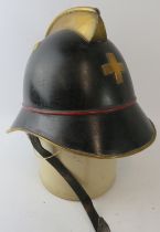 A 1920s Swiss Zurich Fire Service black fire helmet with brass mounts and brass badge