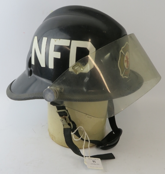 A 1980s US Newark Delaware Fire Department Cairns & Brother Inc black ABS fire helmet with visor