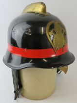 A 1970s Spanish Fire Service black steel fire helmet with brass comb and badge
