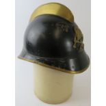 A 1930s German black and brass fire helmet with crossed axe badge