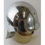 A 1980s West German polished chrome fibreglass fire helmet with leather neck cowl