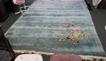 A green ground floral pattered washed wool carpet 271 x 366cm