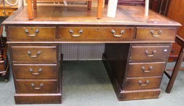 A reproduction mahogany veneer twin pedestal writing desk, leather top, fitted drawers, 137cm wide