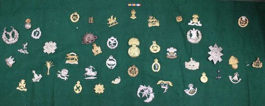 A quantity of military cap badges, includes Gloucestershire regiment, Royal Berkshire, Cameron