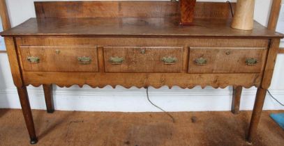 Probably Continental oak three drawer dresser with low upright and shaped apron