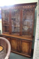 A reproduction mahogany library bookcase, having three astragal glazed doors, over three panel doors