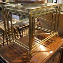 A nest of three brass farmed tables with bevel glass inset