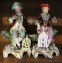 A PAIR OF DERBY PORCELAIN FIGURINES, considered to be circa 1770's, depicting figures seated upon bo