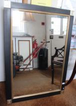 An ebonised and gilt framed wall mirror