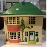 A Tri-ang front sliding metal dolls house in the style of a 1930's suburban home