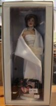 A Franklin Mint "Jackie" doll, depicts Jacqueline Kennedy dressed in one of her iconic outfits, in o