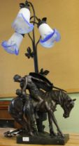 A bronze effect table lamp, warrior on horse with lady and three glass shades