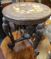 An oriental carved table with insets and stylised elephants legs