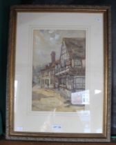 A watercolour painting a street with a half timbered building inscribed W.W Quartermaine. Framed and