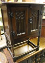 An Old Charm style small cupboard with butterfly hinges and carved doors