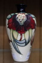 A Moorcroft pottery vase, tube lined and painted floral decoration on a cream ground, impressed and