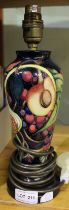 A Moorcroft pottery table lamp, tube lined and painted fruit decoration, polished wood base, height