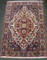 A Persian design wool rug, decorative design on a cream ground, fringed and bordered 109cm x 153cm