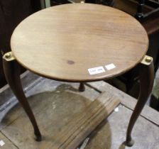 A small circular tripod table with brass fittings