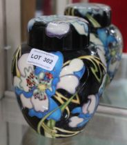 A Moorcroft pottery ginger jar, tube lined and painted floral decoration on a noir ground, impressed