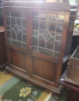 A small leaded glazed door cupboard with a swing mirror