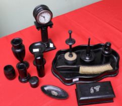 An extensive ebony dressing table set, comprising tray, vase, hat pin stand and a clock on column ba