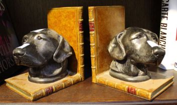 A pair of bronze effect book-ends with dog heads and fashioned as leather book bindings