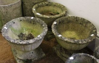 Three small cast garden pots on stands