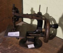 A miniature hand cranked Singer sewing machine