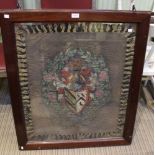 A silk woven panel depicting a coat of arms in a double sided glazed oak frame