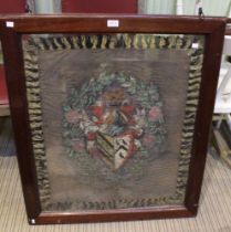 A silk woven panel depicting a coat of arms in a double sided glazed oak frame
