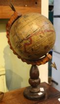 A vintage globe on carved wooden stand