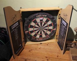 A Unicorn "Phil Taylor" dart board in scoreboard wall mounted case with a table top wooden