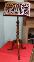 A Regency design duet music stand, pierced mahogany adjustable platforms, with gilded column motifs,
