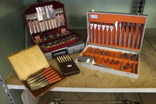 A boxed set of kitchen knives with other boxed examples of canteens