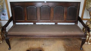 A substantial 19th century oak settle with shell decoration to top panel