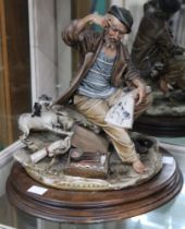 A Capo di Monte ceramic figure of an artist with sketchbook and dog