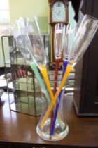 A modern glass vase containing six colour stemmed bud glasses