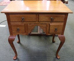 An oak Georgian design low boy, fitted four drawers, with brass handles, raised on cabriole supports