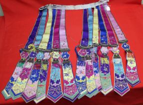 A belt of embroidered, multi silk and embroidered hanging sash panels