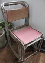 Four mid-20th century tubular metal stacking chairs with canvas backs