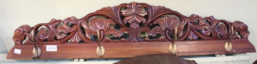 A modern hardwood four hook wall mountable coat / hat rack