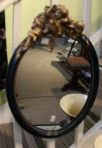 20th century oval wall mirror with gilded cherub decoration