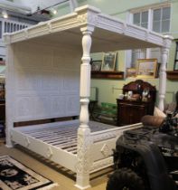 A modern white finished four poster bed, heavily decorated with slats to base, 6' wide x 6.5' long